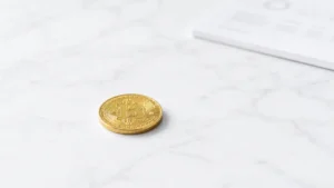 白い大理石の床の上にぽつんと置かれた、1枚の黄金のビットコイン