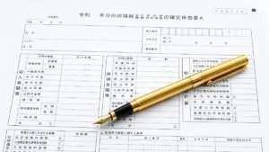 日本の所得税の確定申告書の上に置かれた黄金の万年筆